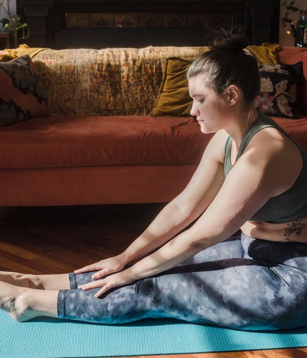 Person in a seated forward bend yoga pose, symbolizing flexibility.